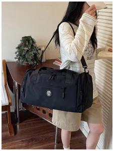 Black travel duffel bag with shoulder strap, large capacity waterproof sports gym bag.