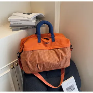 Expandable travel duffel bag detail showcasing orange and blue design, perfect for gym and trips.