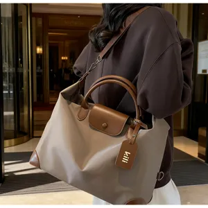 Detailansicht der großen wasserdichten Reisetasche aus Nylon mit Lederbesatz und Griffen.