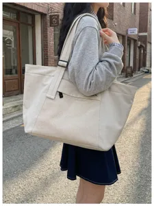 Large capacity casual tote bag with mesh front pocket for commuting, travel, and daily use.