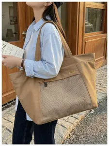 Detailed view of casual khaki canvas tote bag with front mesh pocket and straps.