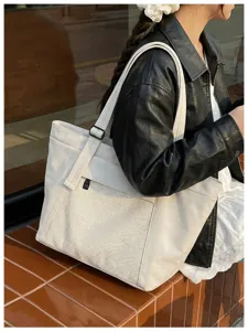 Stylish white tote bag with mesh front pocket, perfect for daily commuting and travel.