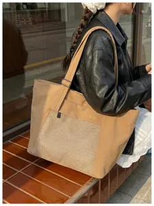 Khaki canvas tote bag detail, featuring front mesh pocket and adjustable shoulder strap.
