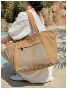 Detail view of the brown canvas tote bag featuring a mesh front pocket and comfortable shoulder straps.