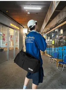Vista detallada de estilo urbano de la gran bolsa deportiva negra para viajes y gimnasio.