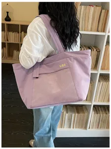 Casual purple canvas tote bag with front mesh pocket and shoulder strap for daily commute.
