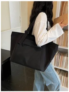 Large black canvas tote bag for women, casual commuter shoulder bag with front mesh pocket.