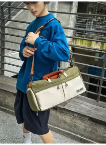 Detalle de bolsa deportiva grande, diseño bicolor con correas naranjas para gimnasio y viajes.