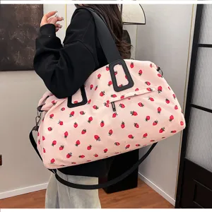 Rosa Kord-Reisetasche mit Erdbeer-Print Seitenansicht Detail zeigt Gurt und Kapazität