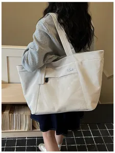 Large capacity casual commute tote bag with front mesh pocket and stylish shoulder straps.