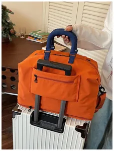 Large capacity travel duffel bag with trolley sleeve, lightweight and waterproof orange.