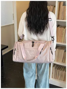 Detailed view of the pink travel duffel bag showing durable fabric and convenient shoulder strap.