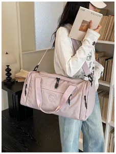 Pink waterproof travel duffel bag with shoulder strap, durable gym bag for women and students.