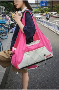 Detailansicht der stylischen rosa-weißen Fitness-Duffel-Tasche, die draußen getragen wird.