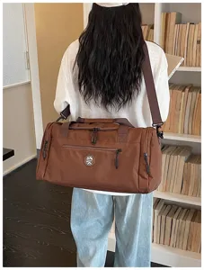 Brown travel duffel bag with shoulder strap, perfect for gym, sports and weekend trips.