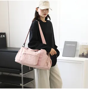 Pink waterproof travel duffel bag with shoulder strap, large capacity gym bag for women.