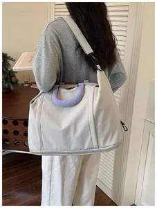 Large capacity canvas travel bag with purple handle, stylish and portable shoulder bag.