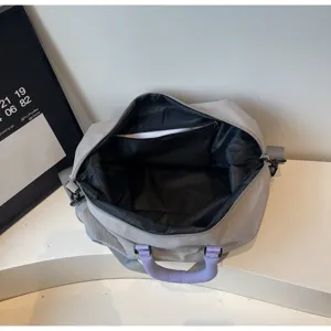 Gray expandable travel duffel bag interior view, gym sports luggage with purple handles.