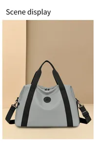Gray travel duffel bag detail, showing large capacity, black handles and clean stitching finish.
