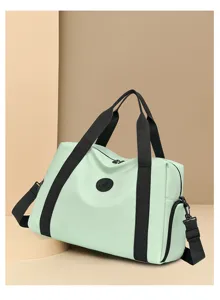 Detailed view of light green travel duffel bag featuring black straps and circular logo badge.