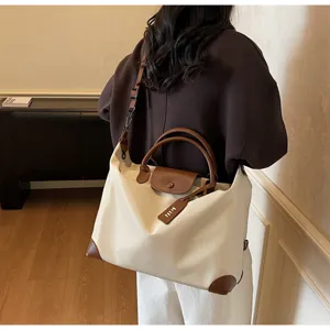 Nahaufnahme der stilvollen Reisetasche mit großem Fassungsvermögen, Lederdetails und Gurt.
