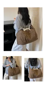 Detail view of brown travel duffel bag with cute bow prints and convenient shoulder straps.