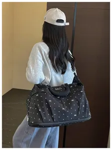 Large capacity black travel duffel bag with white polka dot pattern for gym and trips.