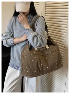 Brown polka dot travel bag detail view, showing large capacity and stylish bow pattern design.