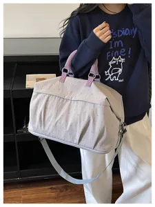 Detail view of expandable travel duffel bag with cute bow pattern, comfortable purple handles.