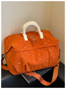 Orange travel duffel bag with cute polka dots, expandable design for gym and weekend trips.
