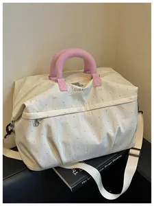 Detailed view of the expandable travel fitness bag with cute bow and polka dot pattern, pink handles.