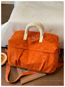 Expandable travel duffel bag with cute polka dot and bow pattern, perfect for weekend trips.