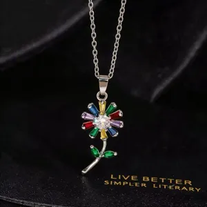 Detalle de un hermoso collar con colgante de girasol de cristal colorido y cadena plateada.