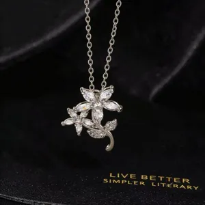 Primer plano detallado del collar con colgante floral de circonita brillante y elegante.