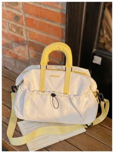 Gran bolsa de viaje y deporte de lona en blanco y amarillo para viajes cortos.