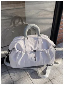 Vista detallada de la gran bolsa de viaje para gimnasio con bolsillo frontal y asas resistentes.
