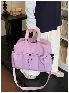 Bolso de viaje morado de gran capacidad con bolsillo de cordón, detalle de bolsa deportiva.