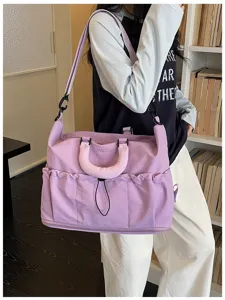 Gran bolsa de viaje morada para deporte con separación húmeda y seca y varios bolsillos.