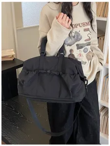 Vista detallada de la gran bolsa de viaje negra para gimnasio con bolsillo de cordón.