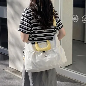 Gran bolsa de viaje de lona para fitness, en color blanco con asas de color amarillo brillante.