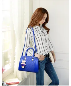 Vue détaillée du sac à main bleu pour femme avec motif gaufré et pendentif ours élégant et charmant.