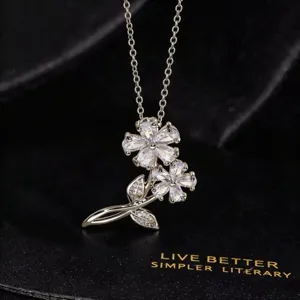 Primer plano detallado del collar con colgante de doble flor de circonita cúbica.