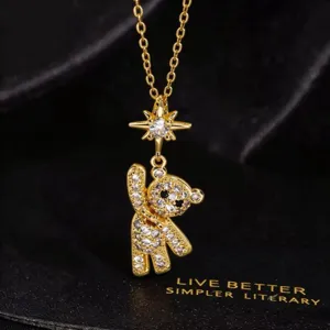 Collar con colgante de oso de peluche de cristal chapado en oro con detalle de estrella.