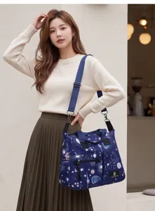 Vue détaillée du sac à langer bleu stylé avec motifs d'étoiles, bretelles durables et poches.