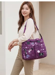 Grand sac à langer violet avec motif galaxie, bandoulière réglable et multiples poches.