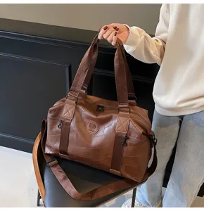 Detailed view of the brown patchwork travel duffel bag showing handle and texture.