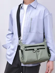 Utility multi-pocket crossbody bag, casual nylon shoulder bag with zipper and round pulls.