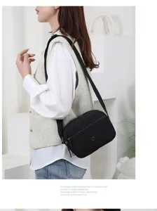 Gedetailleerd overzicht van de zwarte nylon schoudertas, meervoudig design, licht en casual.