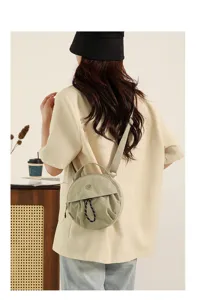 Détail du sac bandoulière rond et tendance, avec sangle confortable pour un usage quotidien.
