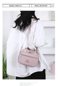Vue détaillée du sac à bandoulière en tissu oxford rose avec fermeture éclair et logo.